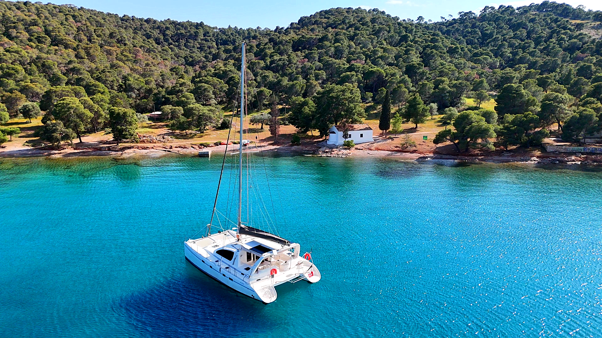 catamaran de croisière au mouillage sur une mer bleue, calme et limpide.
